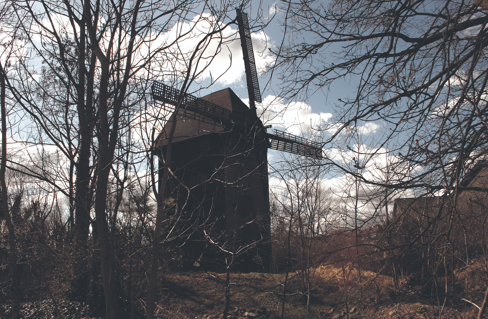 Versteckt hinter Bäumen: Die historische Bockwindmühle an der alten Poststraße