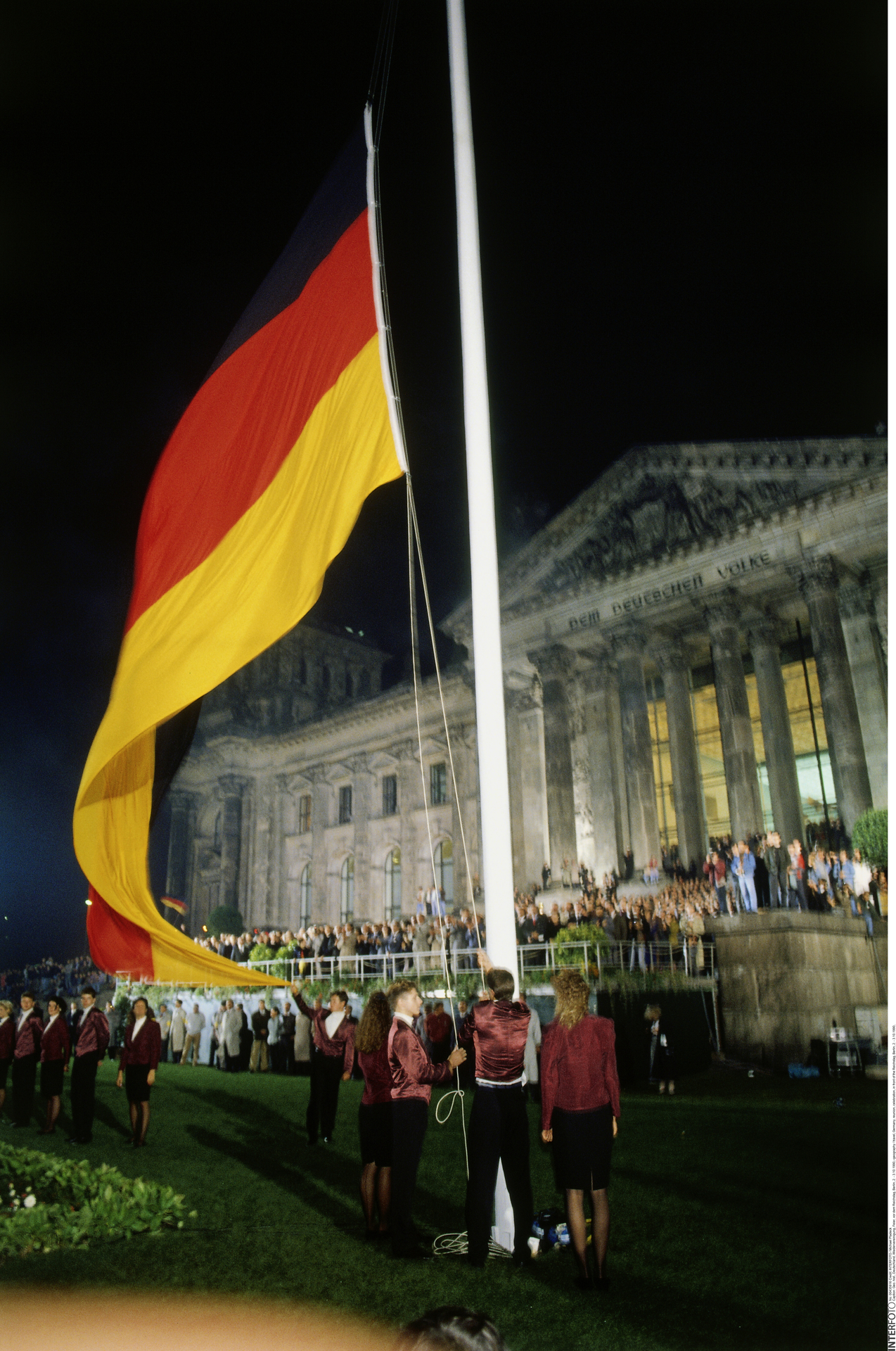 Am 3. Oktober 1990 um 0 Uhr war es so weit: Als Symbol der Vereinigung hissen sieben junge Sportler aus der Altbundesrepublik und dem Beitrittsgebiet begleitet von Feuerwerk und Nationalhymne vor dem Reichstag die sogenannte Flagge der Einheit