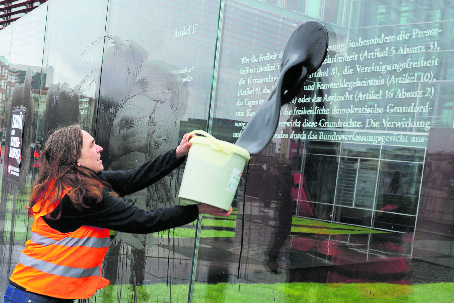 Links-grüne Randalierer der Gruppe „Letzte Generation“ beschmieren mit einer schwarzen Flüssigkeit die gläsernen Wände des Kunstwerks „Grundgesetz 49“ des israelischen Künstlers Dani Karavan im Berliner Regierungsviertel